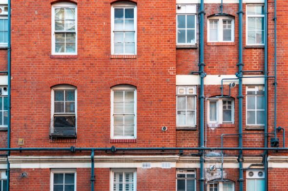 facciata condominio in mattoni rossi e tubature nere