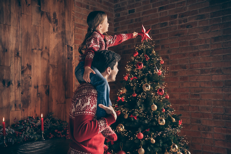 Padre e figlia addobbano l'albero di Natale