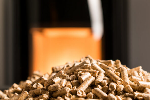 Pellet in primo piano e stufa sullo sfondo
