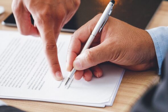 una persona firma un documento