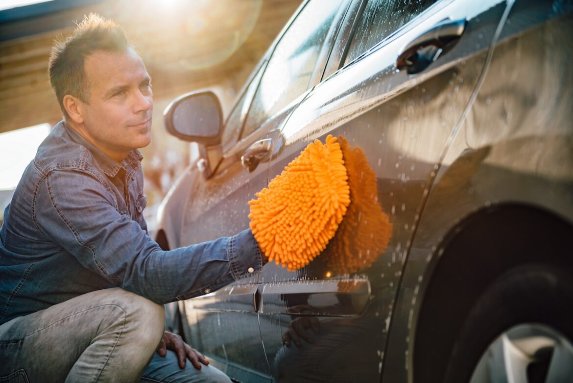 un uomo lava la macchina