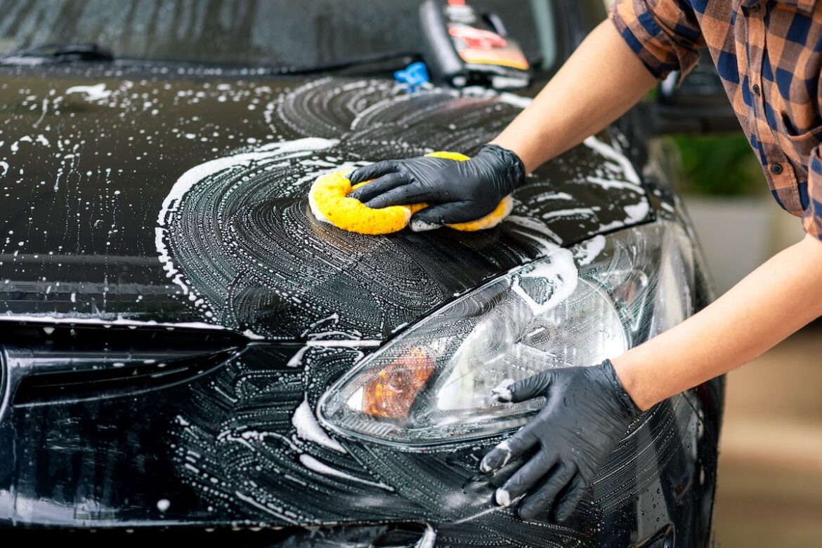 una persona lava l'auto