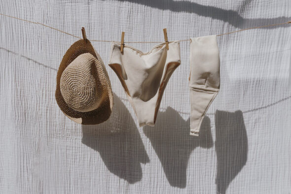 costume da bagno steso, con infradito, cappello e occhialini