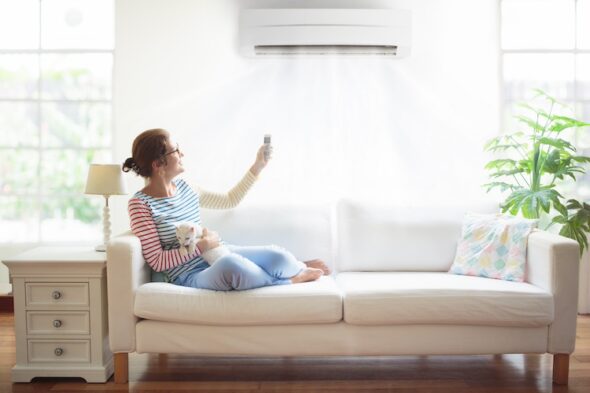 una persona sul divano aziona il condizionatore