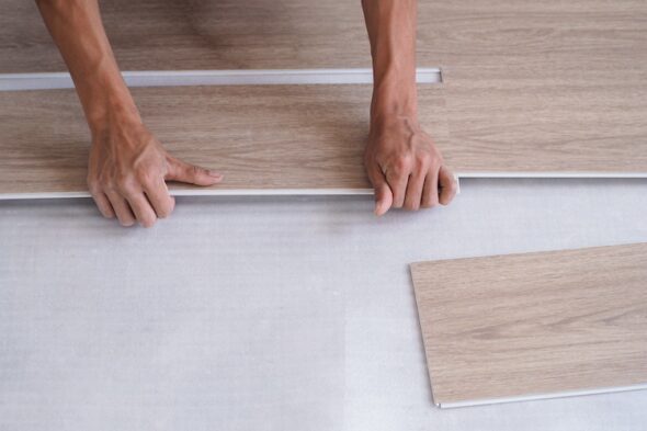 una persona monta il pavimento in PVC