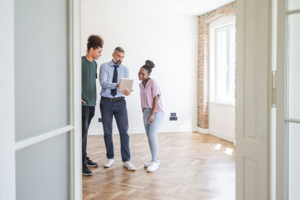 agente immobiliare fa vedere casa a due persone