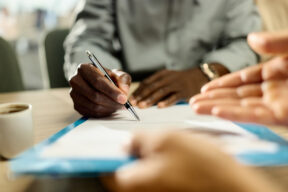 Mani che firmano un contratto