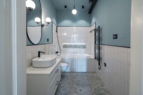 bagno moderno con piastrelle bianche a metà muro e parete azzurra