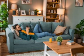 persona si rilassa sul divano in una casa accogliente